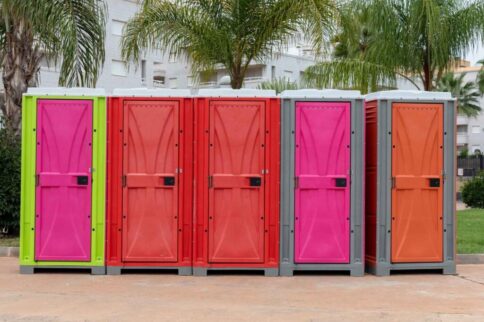 Multiple colourfull portable toilets.